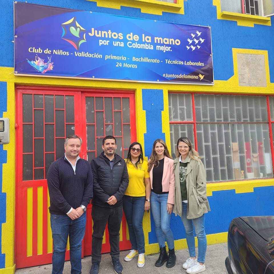 Varias personas unen sus manos en el centro de un círculo como símbolo de trabajo en equipo