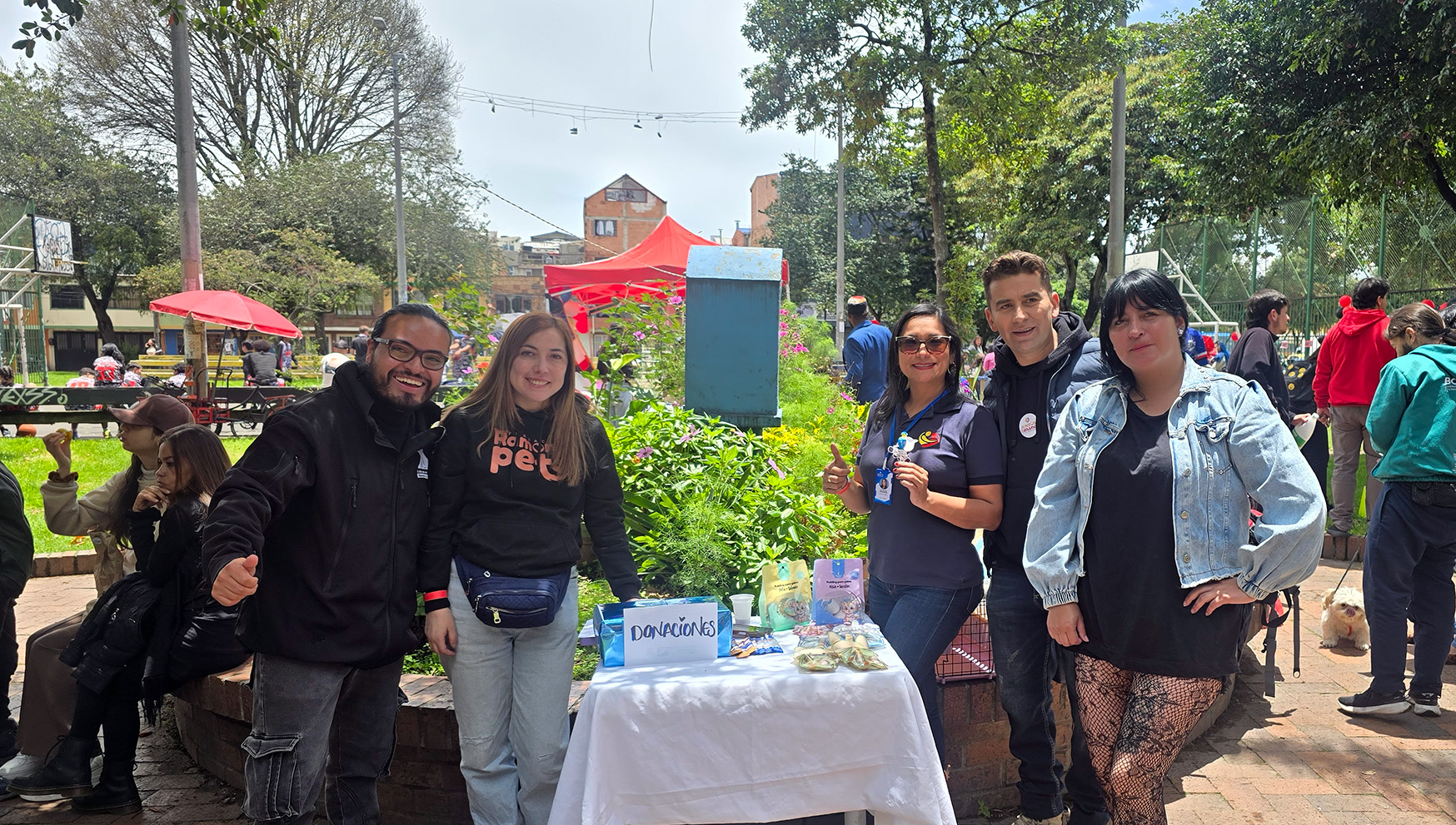 Personas reunidas en una huerta comunitaria rodeada de árboles